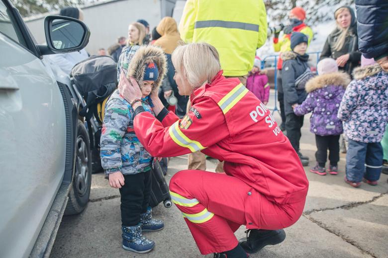 Worker comforts child refugee
