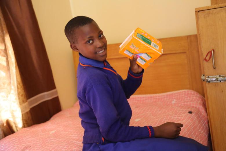 A girl in Rwanda showing pads in the Menstrual hygiene room