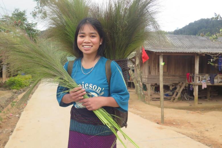 Xa stands holding a plant