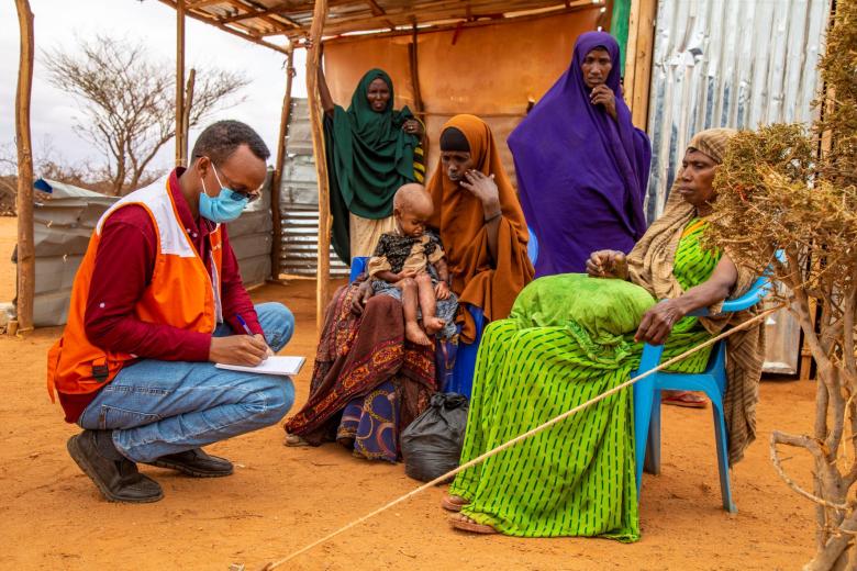 World Vision staff helping a sick child in a community