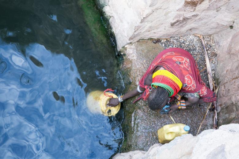 An elderly woman fetches water in Northern Kenya amid the drought and water streses