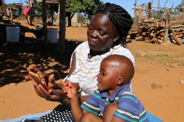 A mother helps son to study online.