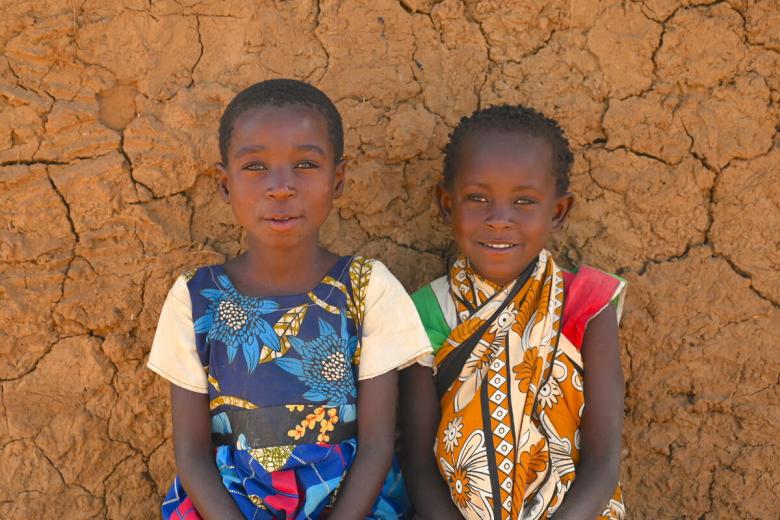 Children sitting against a wall
