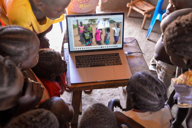 Children watching video of themselves on laptop