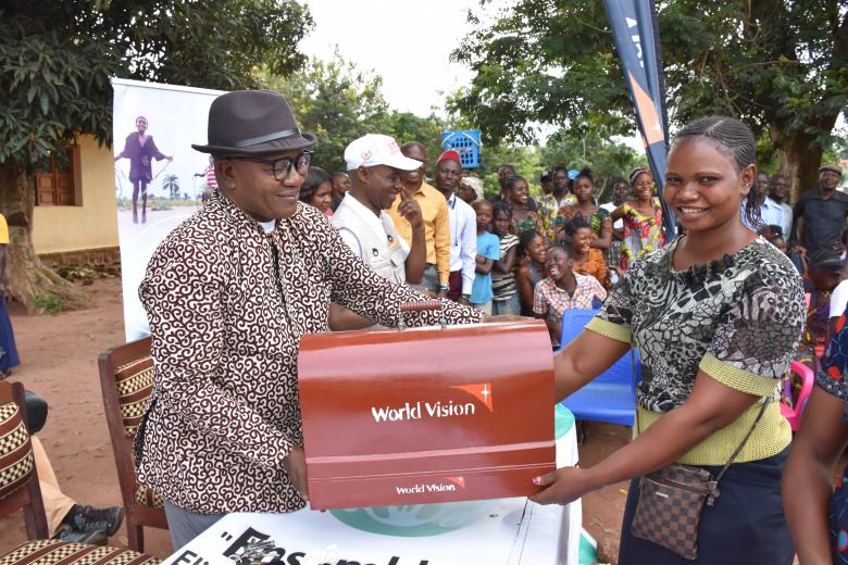 A beneficiary receiving her machine from World Vision
