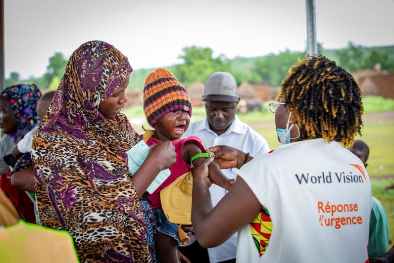Rachel, the community health worker checks the child's nutritional status