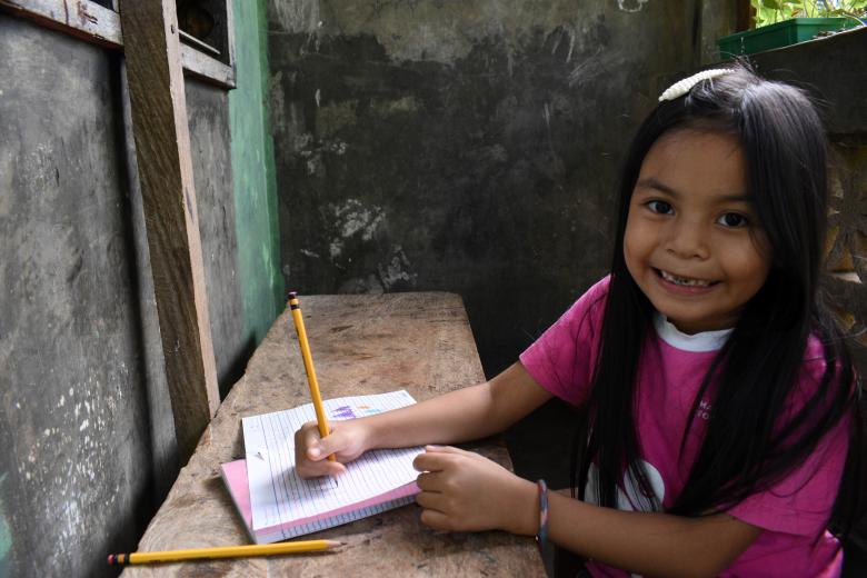 6-year-old sponsored child Glea learning how to read and write