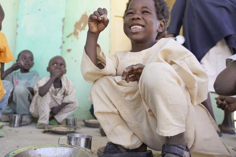 Child enjoying food provided in school through World Vision's school feeding programme