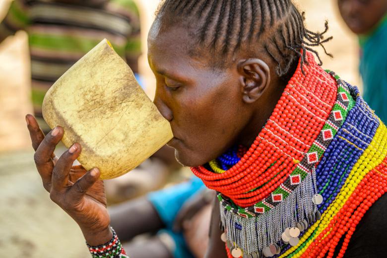 Pauline takes a drink, outside her home in Kalapata AP, Turkana, Kenya
