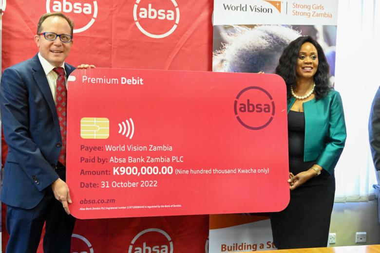 World Vision Zambia National Director John Hasse and Absa Bank PLC Chief Executive Officer Mizinga Melu holding the dummy cheque after signing the MoU