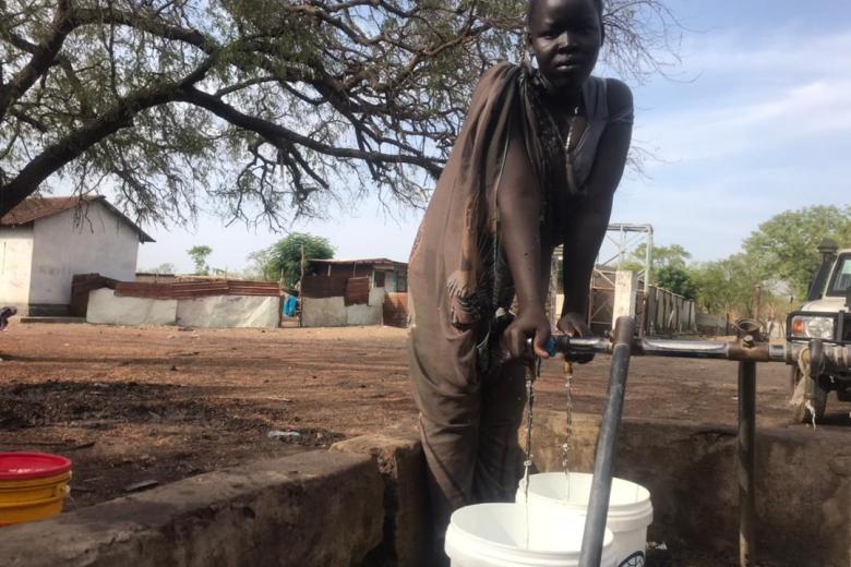 Girl fetches clean water from one of the water