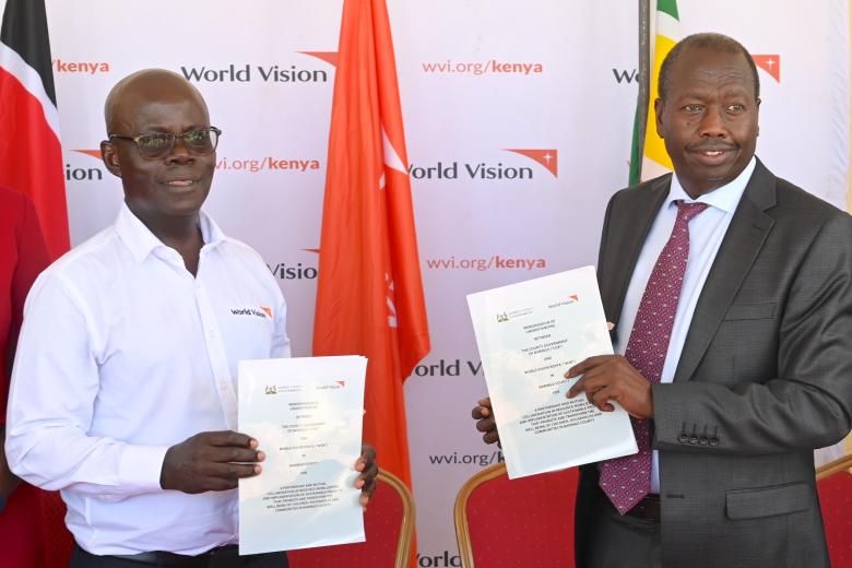 Gilbert Kamanga (left), the National Director of World Vision Kenya and Benjamin Cheboi hold the signed Memorandum of Understanding (MOU) between the two organisations.