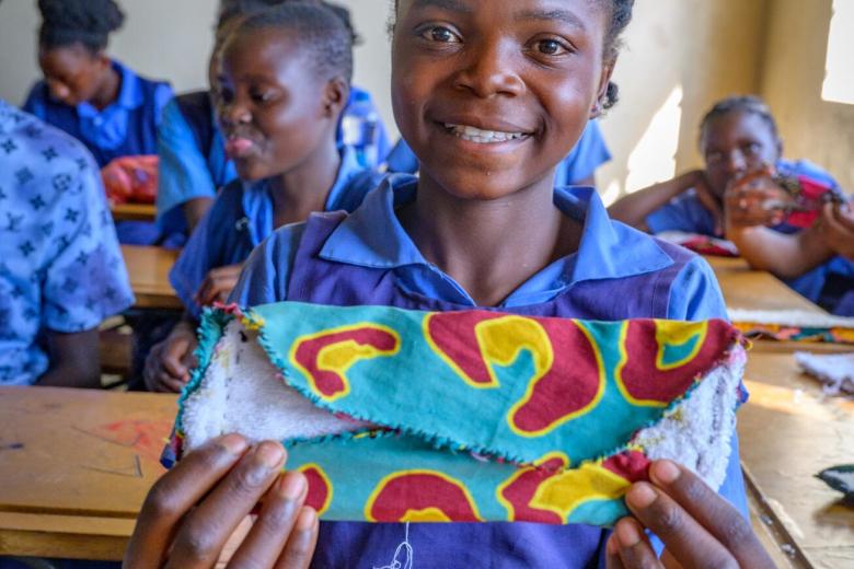 Girl in Zambia making sanitary pad as part of WASH UP programme