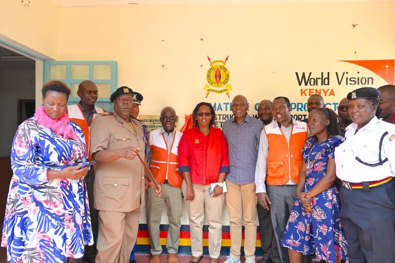 World Vision staff, Kenya Police Service representatives, County government officials among other stakeholders and members of the public pose for a picture outside the Matete Child Protection Unit that was constructed through the support of World Vision.
