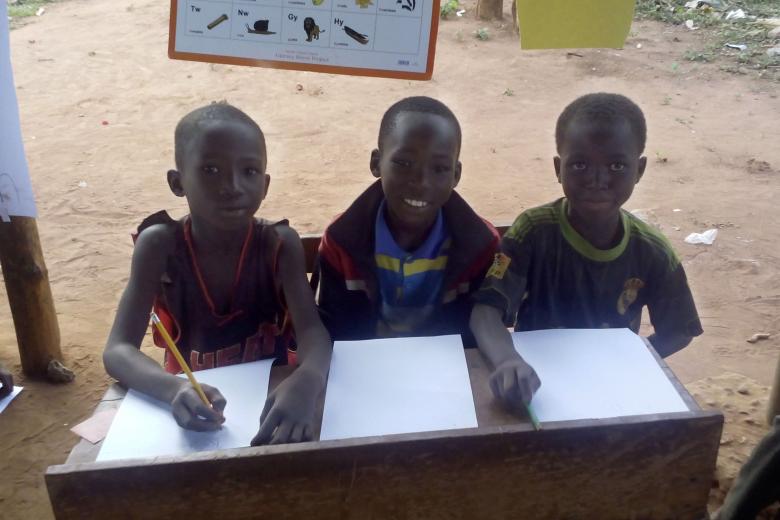 Children smile at a Literacy Boost reading club in Ghana