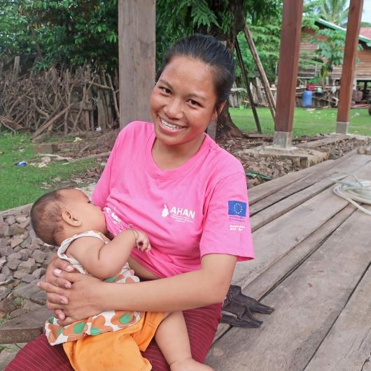 Nok breastfeeds her child in Laos
