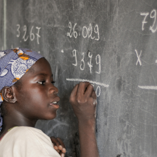a child writing on a chalkboard