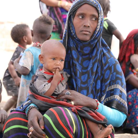 Mother displaced by violence, sits with child in Tigray Ethiopia