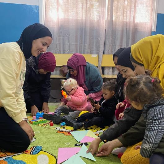 Group of Mothers supported by a volunteer on early childhood development