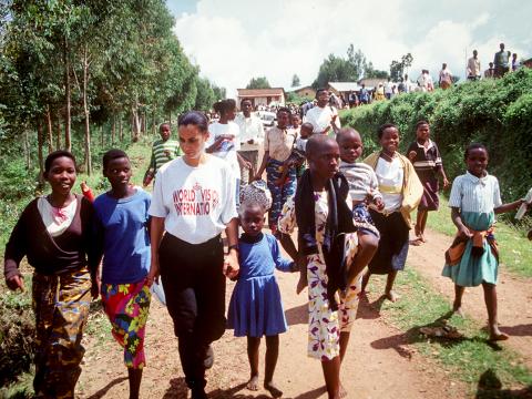 WVI Employee walking with children during Rwandan Genocide