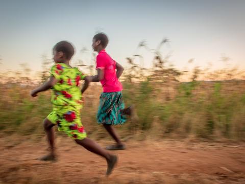 Two children run down the road