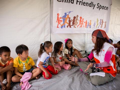 A World Vision worker speaks with children during an emergency