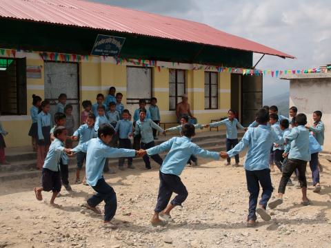 Children play outside a school in Nepal