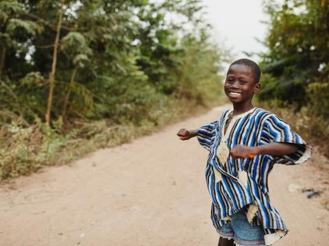 A boy dances on a road in Ghana