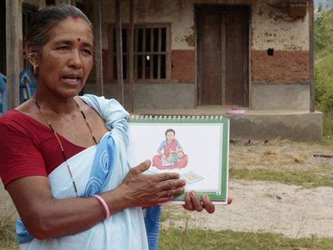 A child health worker holds a training document