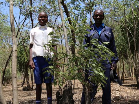 Charles Abongo (right) with his son Biron at their farm in Homabay County which has over 900 trees.