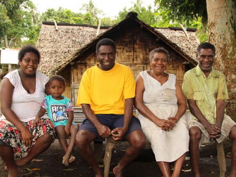 •	John (centre) is the REACH project faith leader. His family (pictured) is proud that he champions gender equality. 