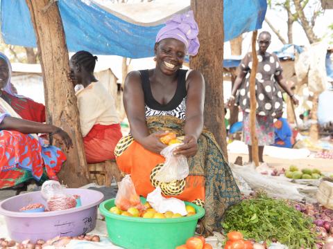 Yabang sorting tomatoes for her customer