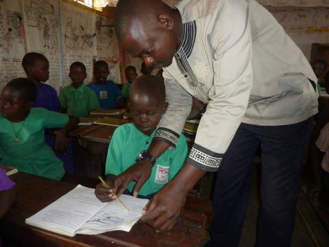 John Omara, teaching one of his students how to pronounce a word.