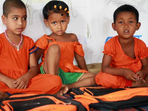 Mousumi is carrying her younger daughter Nusrat, 4, to World Vision facilitated Learning Roots Centre in Shribordi Area Programme