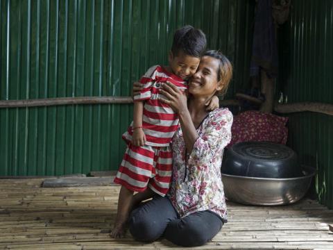 Khmer mother smiles and hugs her son