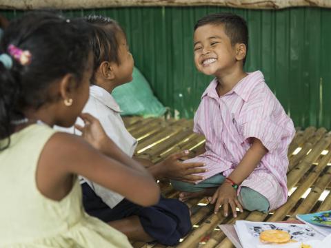 Young Khmer boy grins broadly to his friends