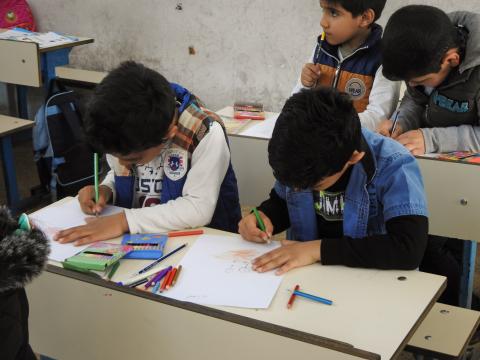 Children of grade one drawing their negative emotions during the Mandala psychosocial support session in Iraq