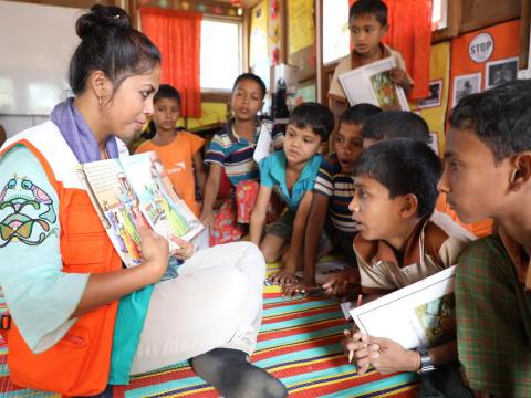 World Vision child protection coordinator Shampa Kundu reads a story book to children attending World Vision's Multi-Purpose Child and Adolescent Centre in the Rohingya refugee camp in Cox's Bazar, Bangladesh.