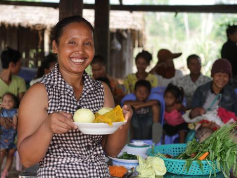 Khmer woman hold bowl of cut vegetables ready to do nutritious food cooking demonstration, Cambodia