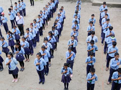 Students of Kalika Devi School sing the national anthem during morning assembly 