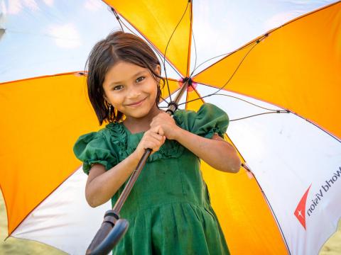 Rohingya refugee girl with World Vision umbrella