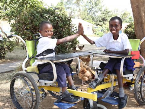 Gift (right)and his friend play at Masaku Primary School in Kenya's Machakos County. The wheelchairs, donated by World Vision, have enabled the children perform tasks independently and play with friends. @World Vision Photo/By Hellen Owuor.