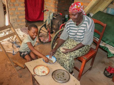  Josephine and her grandchild Maggie eating Nshima-- the staple food in Zambia made from finely ground corn meal, called mealie meal. 