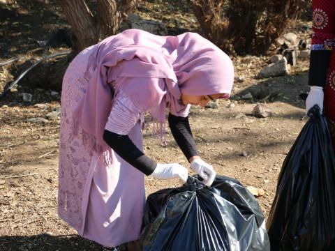 young girl with trash bag