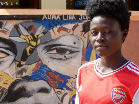 Lina Auma posing next to her superwoman portrait