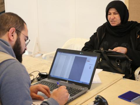 World Vision staff collect information from a woman