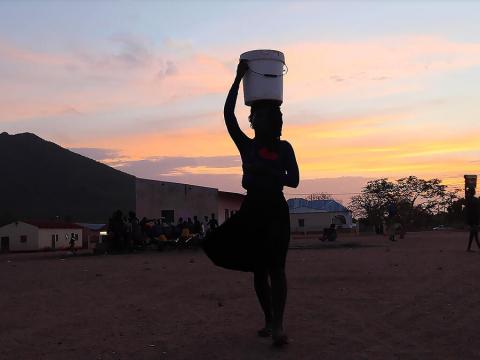Woman holding water bucket over head