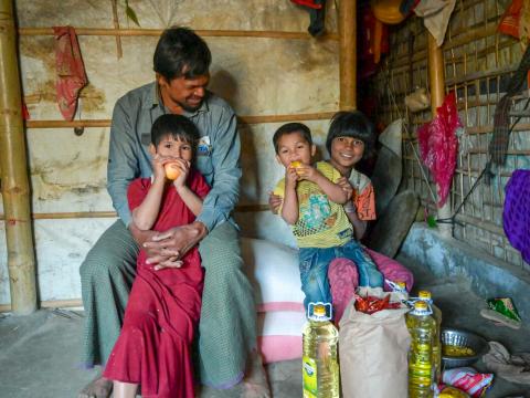 Najir’s children enjoy the apples he bought as part of monthly food ration from the World Food Programme e-voucher store, which is run with support from World Vision.