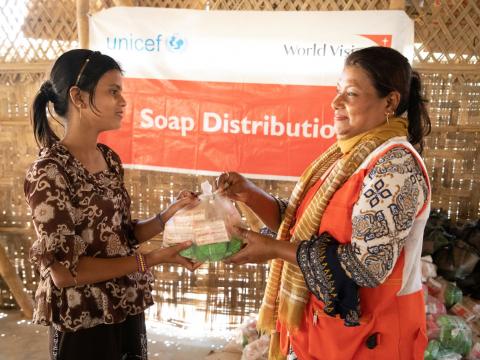 A child receives soap from a World Vision staffer