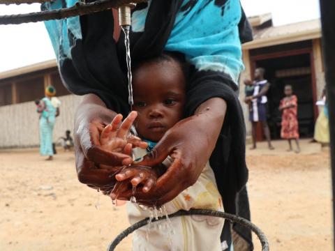 Mother washing he child's hand with clean water
